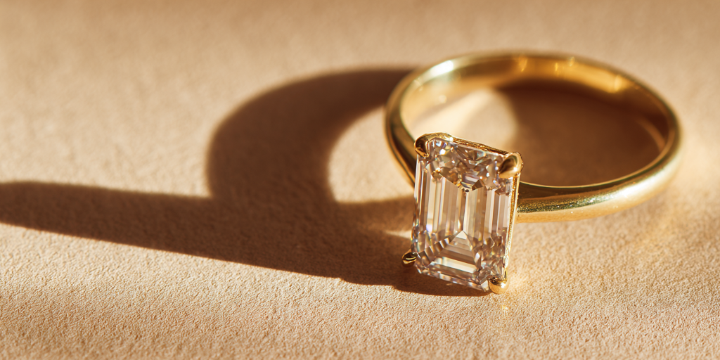 Emerald cut diamond ring on warm beige background