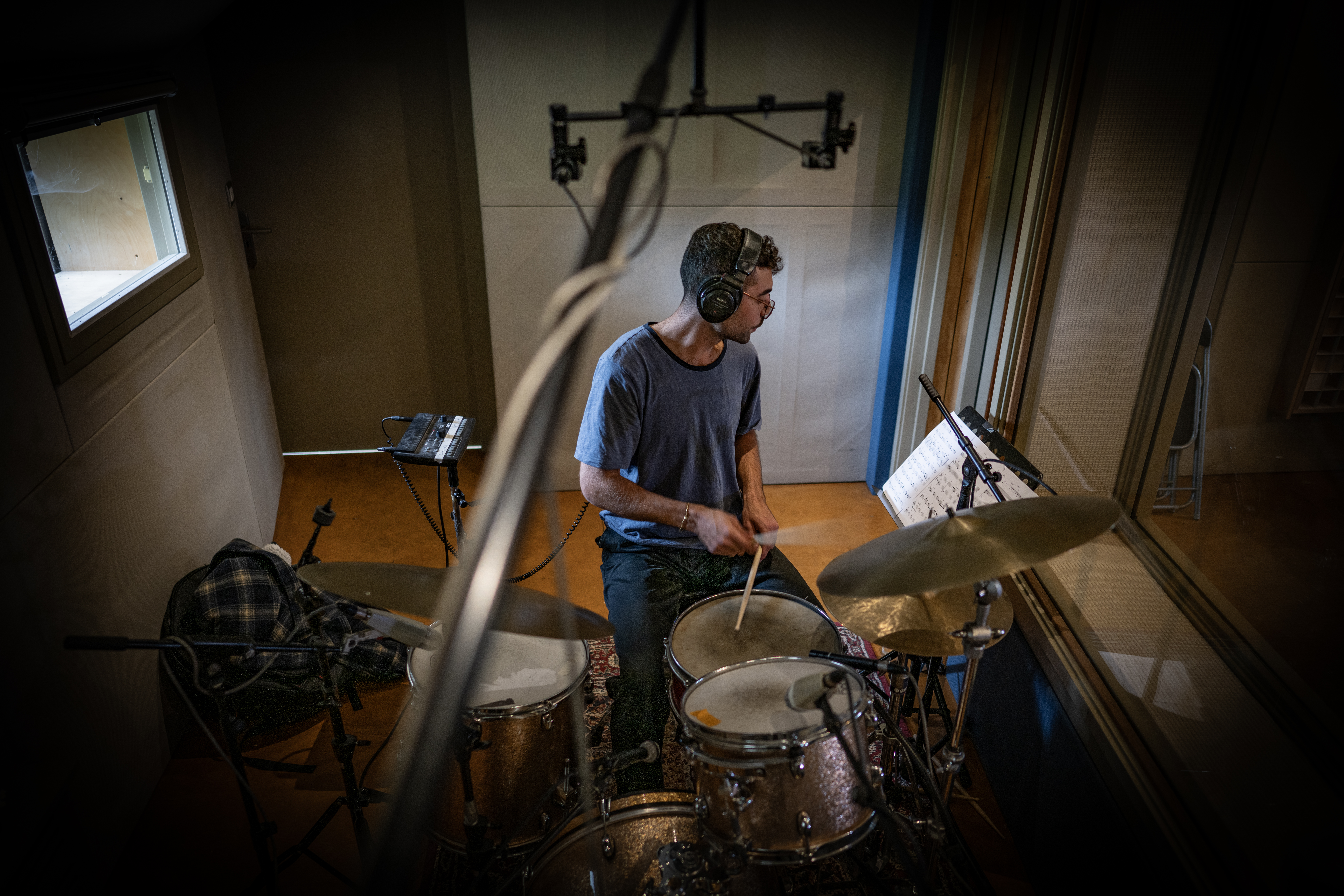 An overhead view of the drummer wearing headphones at the studio drum kit.