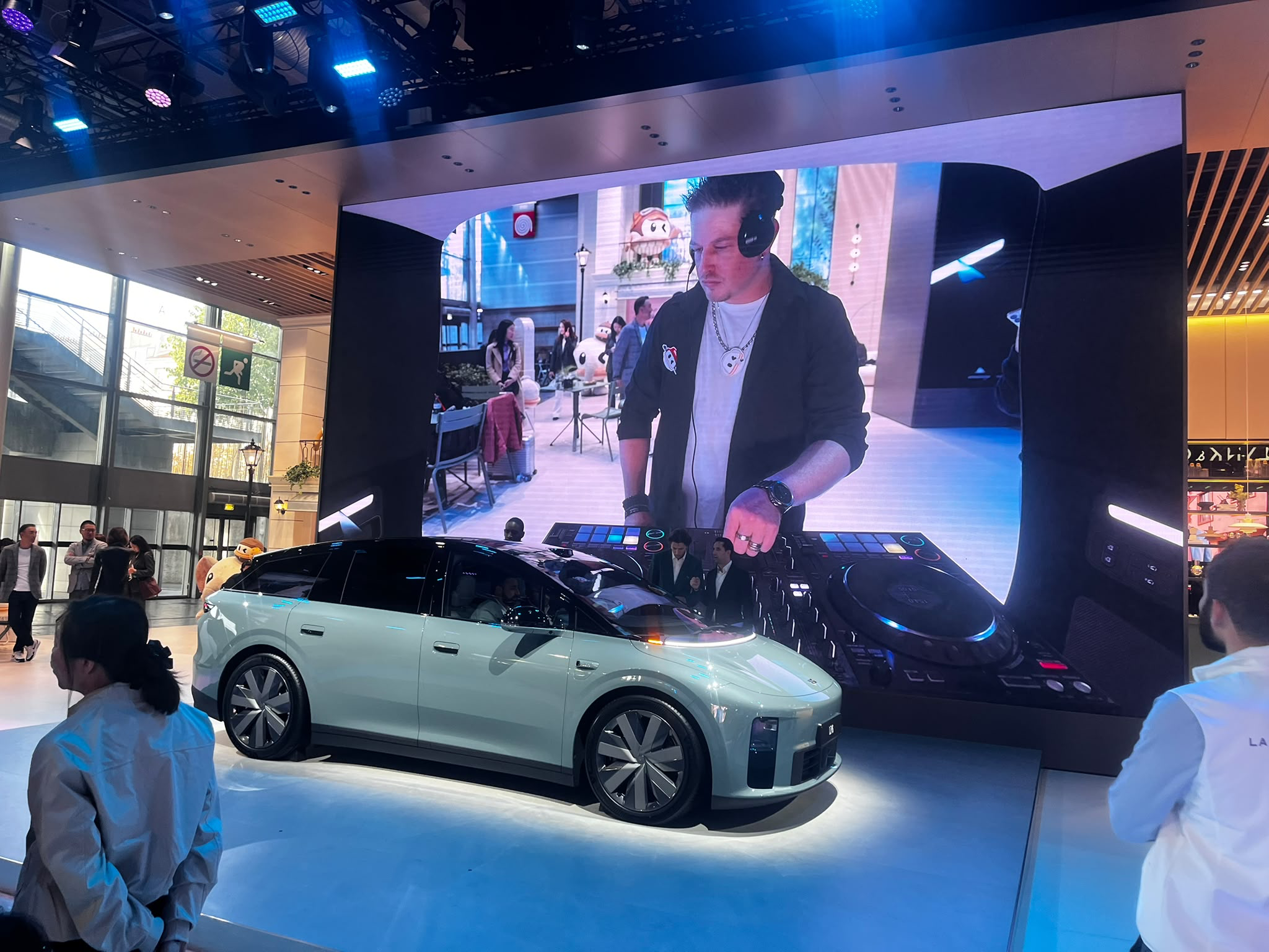 Visiteurs devant le DJ set Booking Paris Mix sur le stand Li Auto