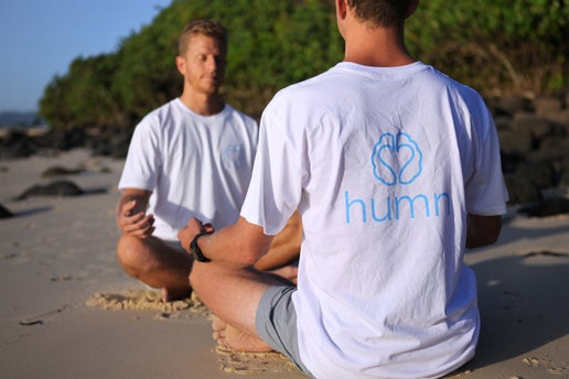 Two people meditating on the beach