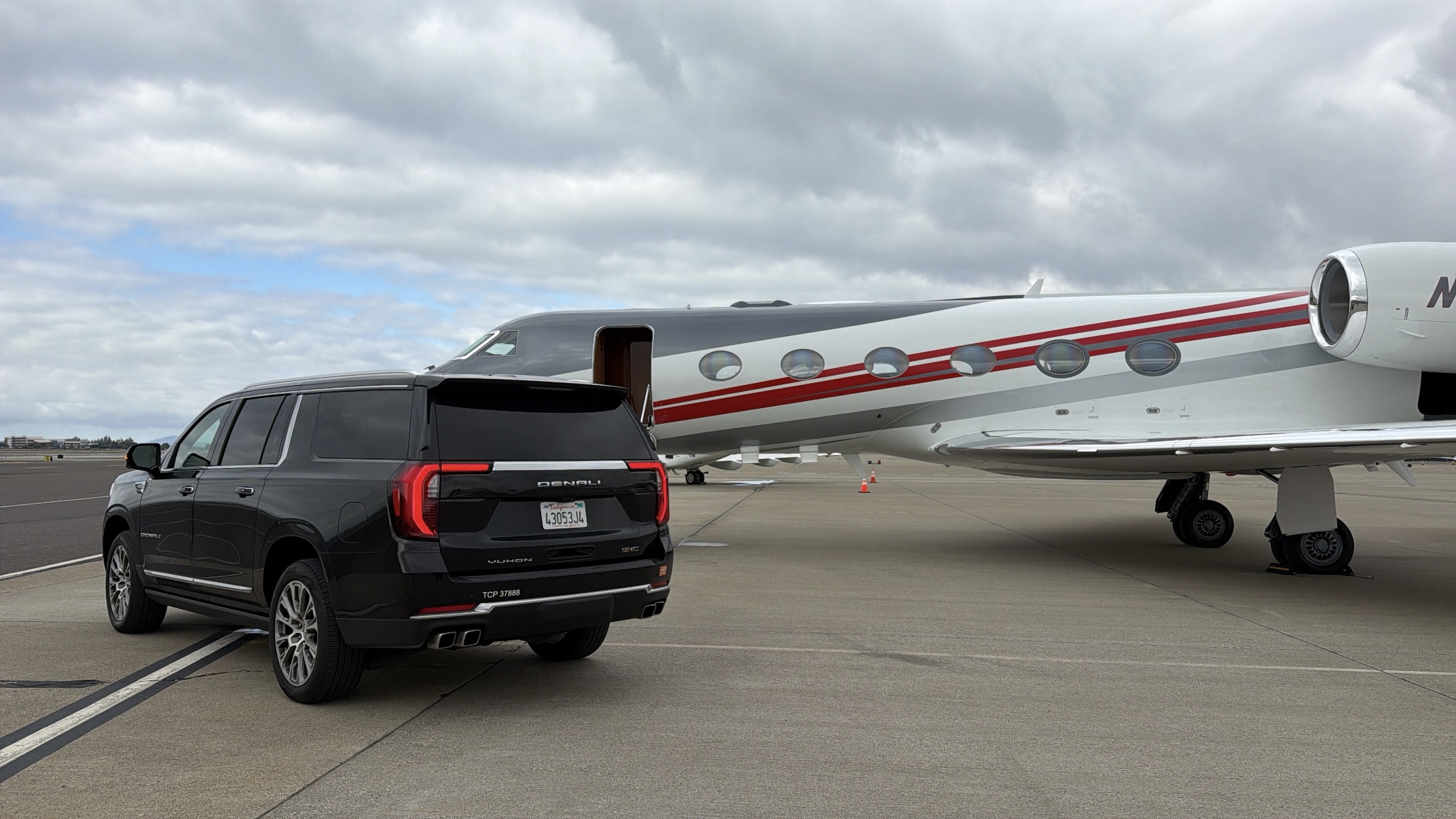 Chauffeur SUV and a private jet on the MIA tarmac