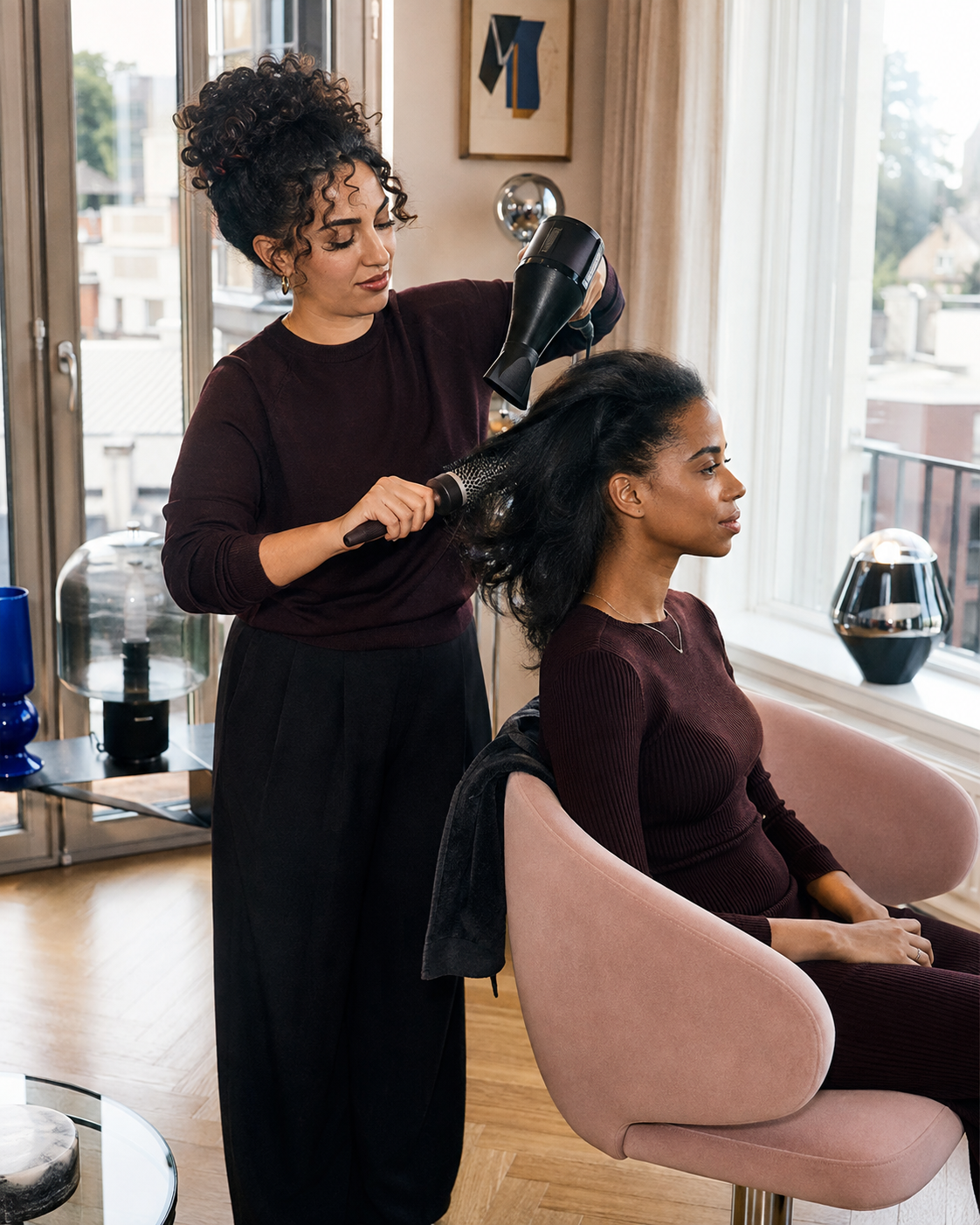 Coiffeuse réalisant un coiffage à domicile pour une cliente