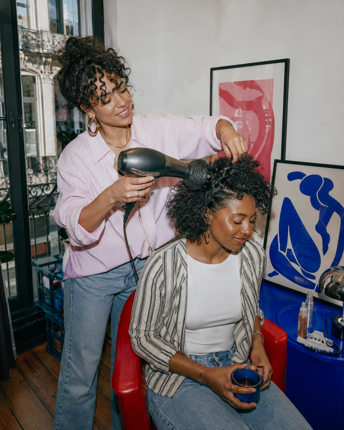 Coiffeuse séchant les cheveux d'une cliente à domicile