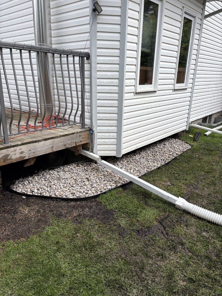 Backyard drainage project — Finish product. Drainage, re-used grass economically, and finished with rocks — MW Construction and Landscaping in Edmonton & Beaumont, Alberta
