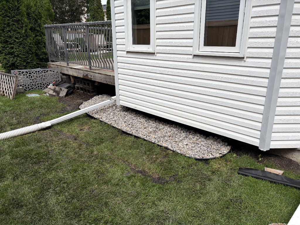 Backyard drainage project — Finish product. Drainage, re-used grass economically, and finished with rocks — MW Construction and Landscaping in Edmonton & Beaumont, Alberta