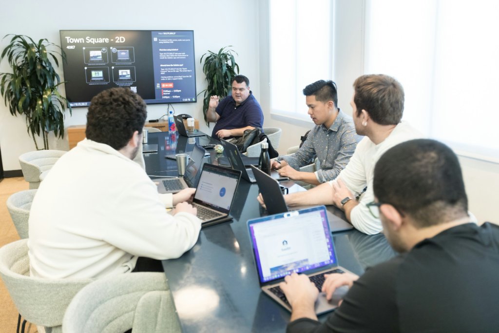 Team working on modern laptops in a London meeting room after a LANIX hardware lifecycle refresh and device rollout