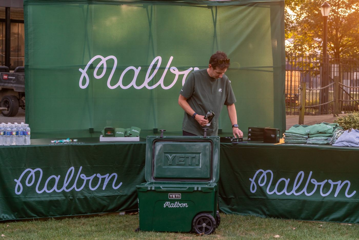 Sponsor booth being set up at golden hour before a Thursday Night Lights event