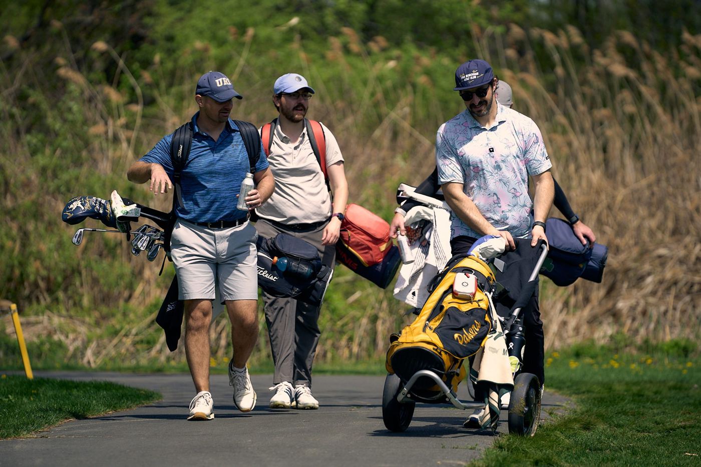 Three members walking the fairway with their bags