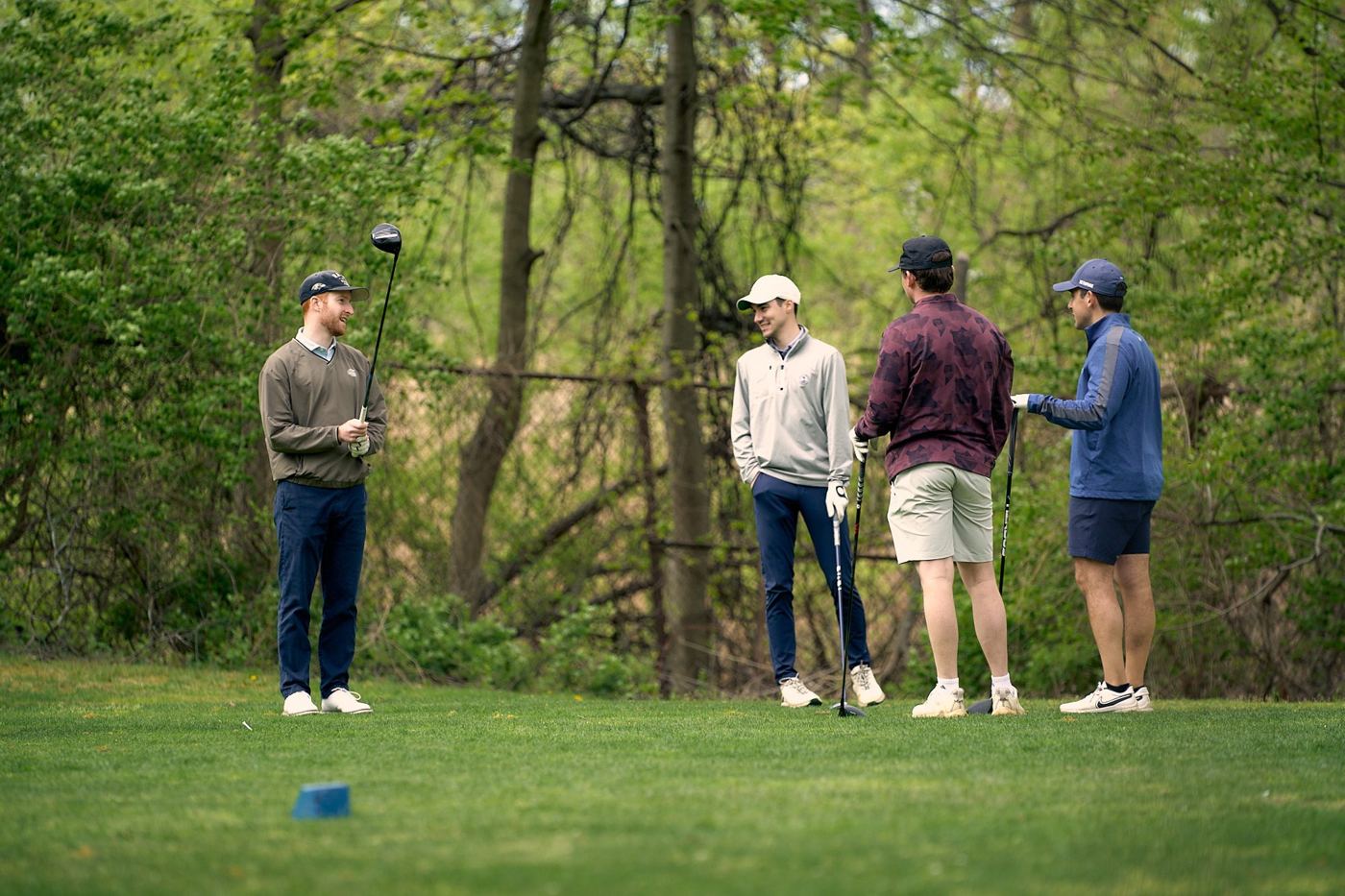 Four members talking on a tee box