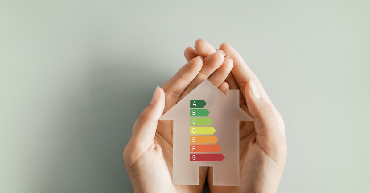 Ein digitaler Energieausweis auf einem Tablet-Bildschirm neben einem Schlüsselbund vor einem unscharfen Haus.