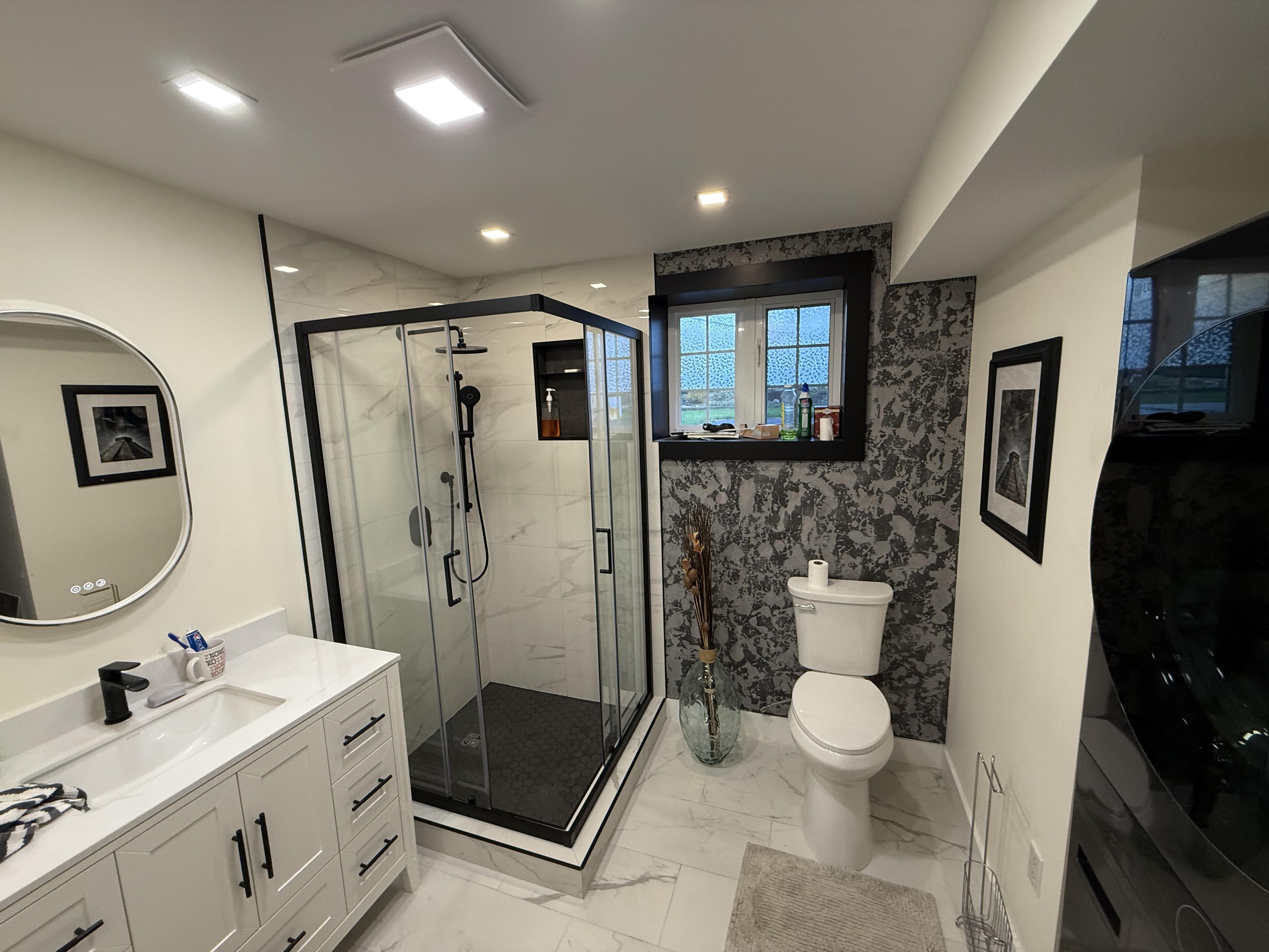 Walk-in shower with black-framed glass and marble tile — VP ReNewWay St. John's NL