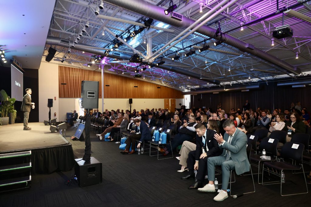 Topher Stephenson speaking to a large audience at a commercial real estate conference