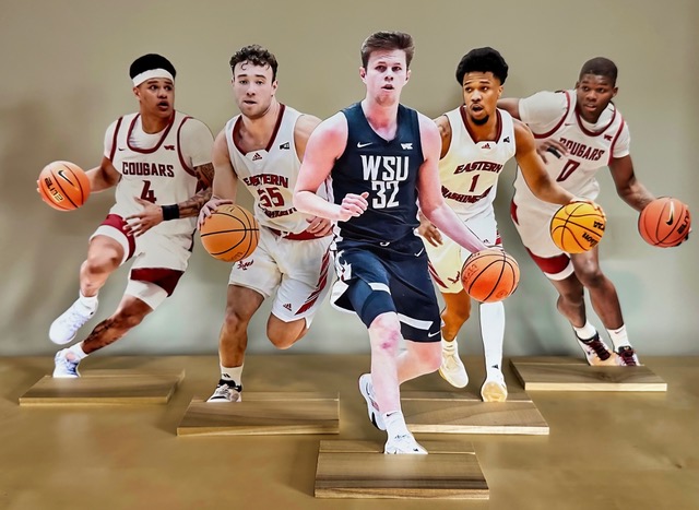 Washington State and Eastern Washington basketball player stand up awards in Coach David Riley's office