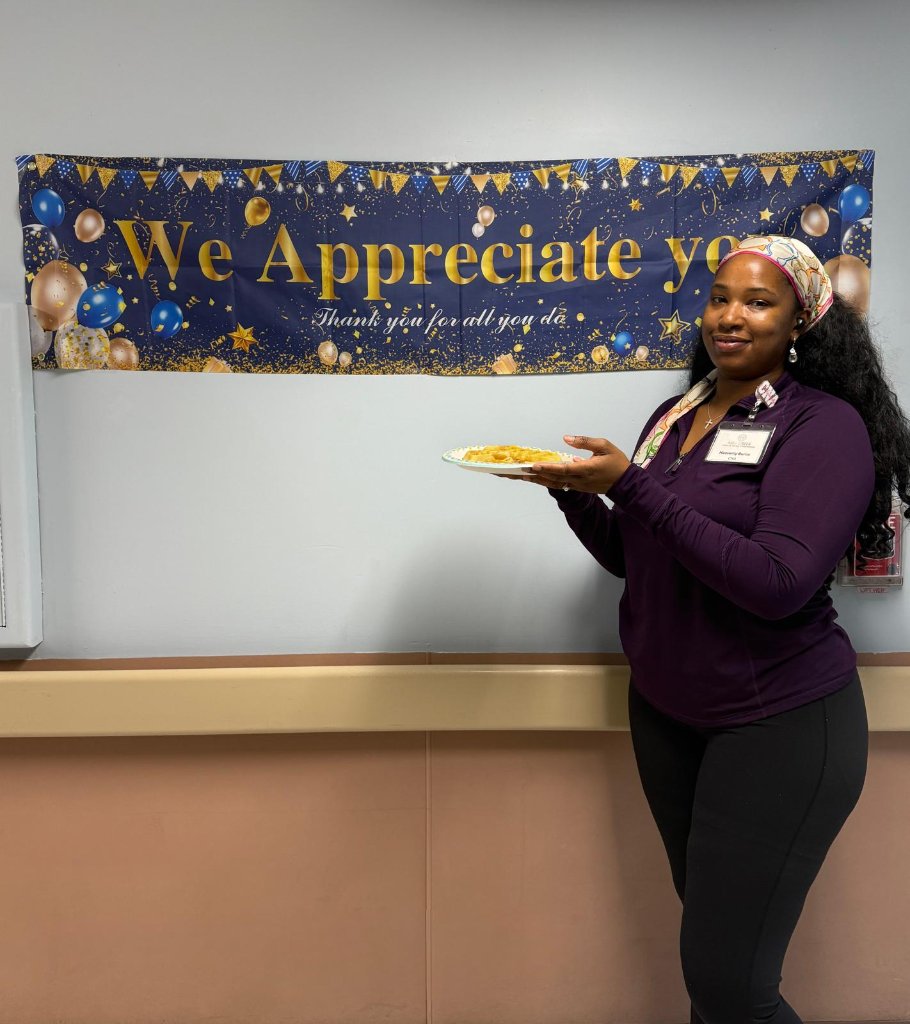 Staff posing with waffles in front of appreciation banner