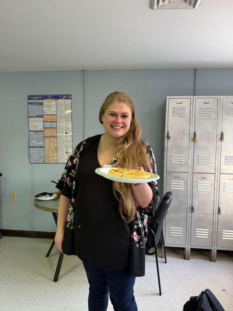 Employee posing with waffles and red cup at appreciation event