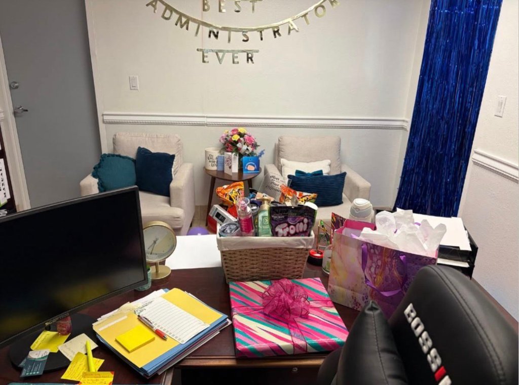 Administrator's office decorated with 'Best Administrator Ever' banner and gift basket.