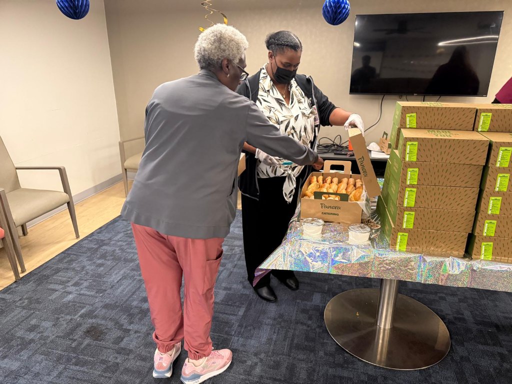 Staff member opening Panera catering box at appreciation event