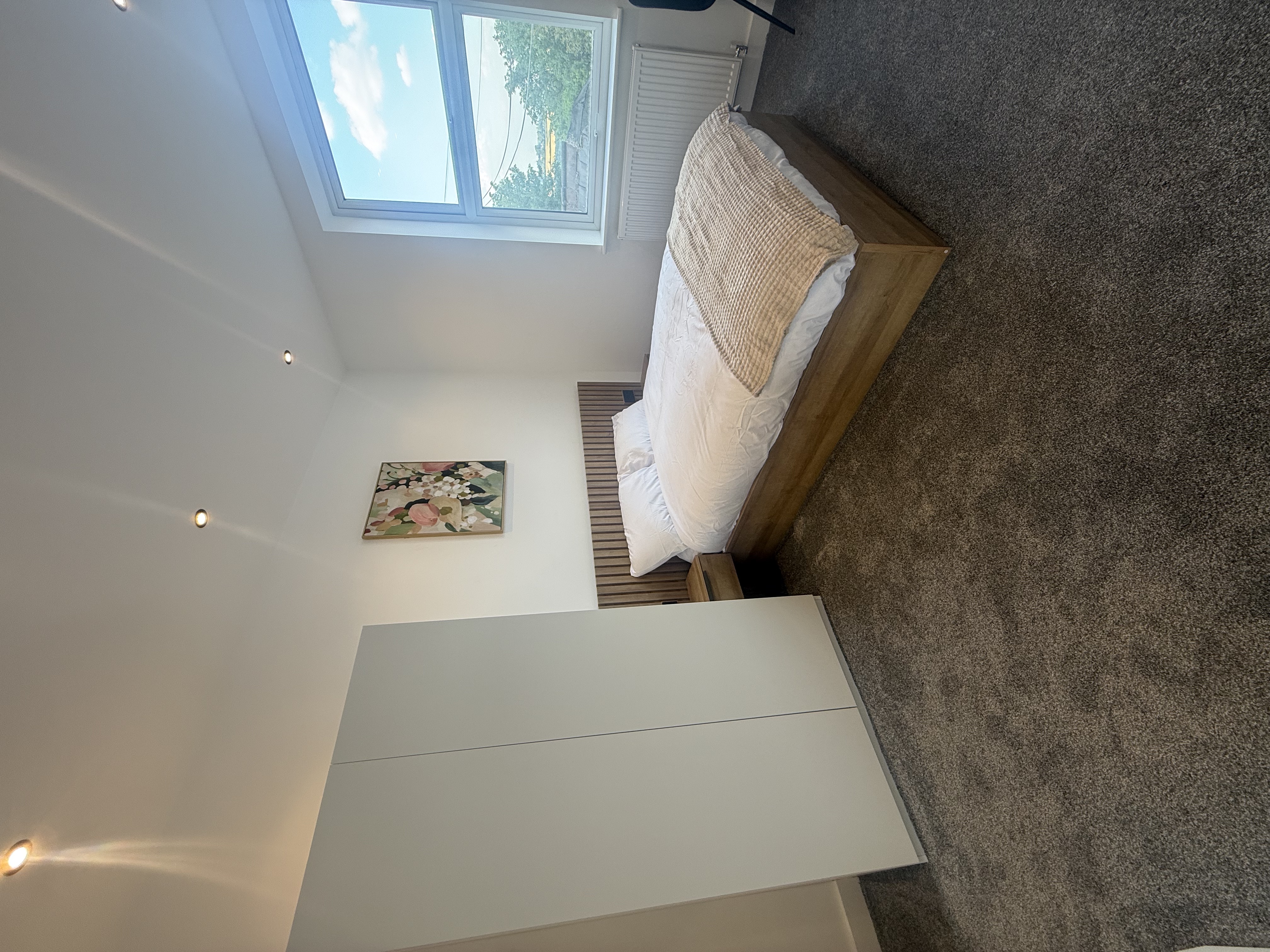 Bedroom with feature headboard & abstract art