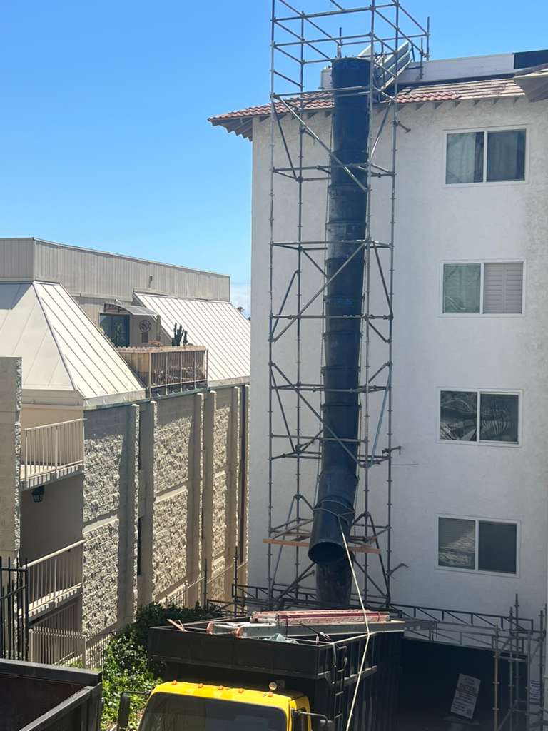 Trash chute with yellow dump truck