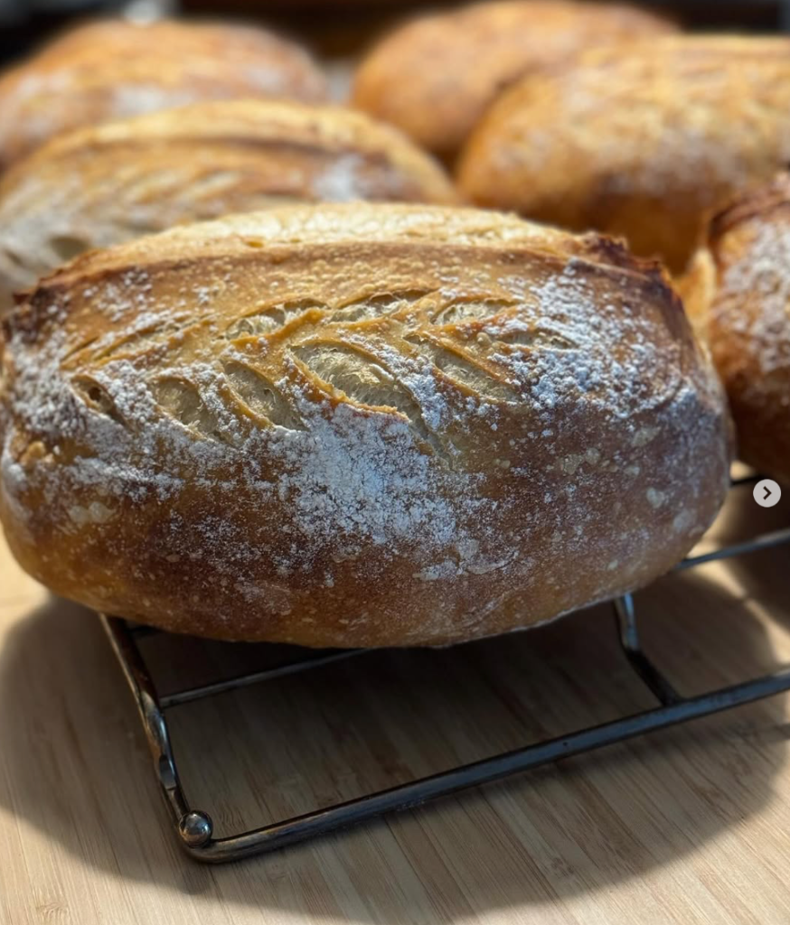 Freshly baked sourdough loaf with wheat stalk scoring
