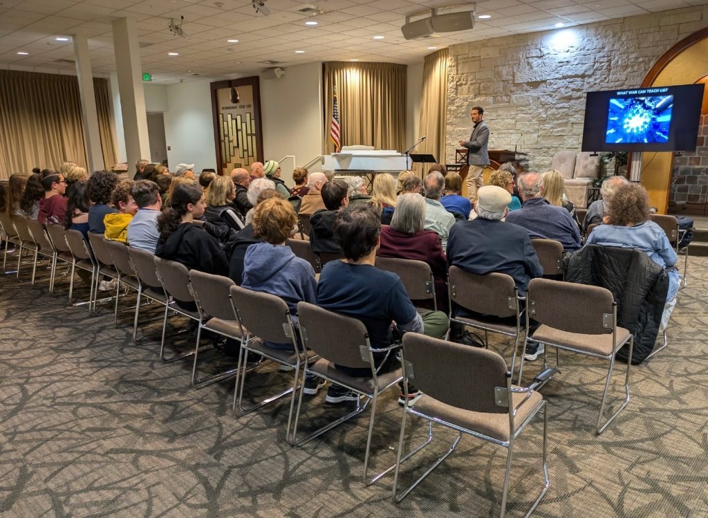 Yoni Asseraf speaking to a community audience in Los Angeles