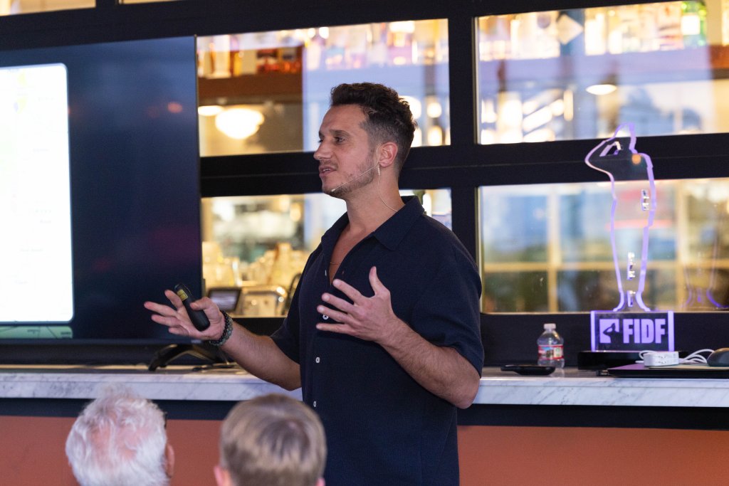 Yoni Asseraf speaking at a FIDF event with headset microphone