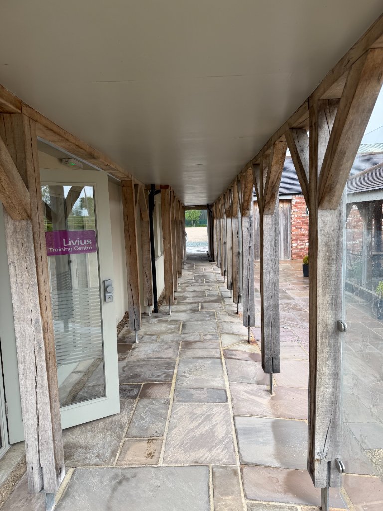 Covered walkway with oak beams leading to Livius Training Centre entrance