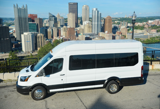 Greene Valley Shuttle party bus with the downtown Pittsburgh skyline — chauffeured party bus service across the city.