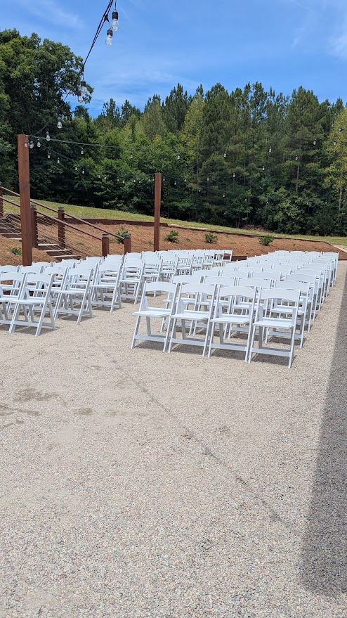 Outdoor ceremony seating beneath string lights
