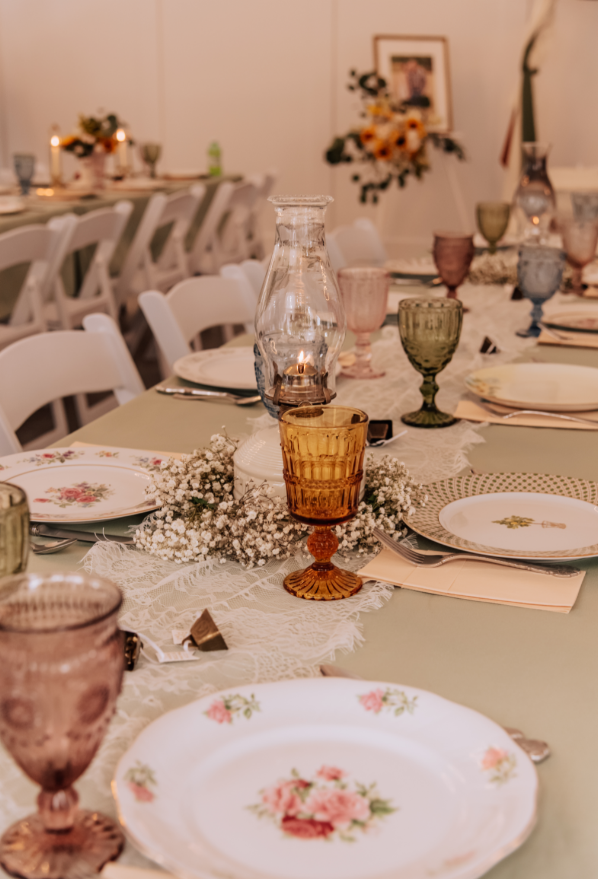 A romantic reception tablescape with candlelight and delicate floral details.