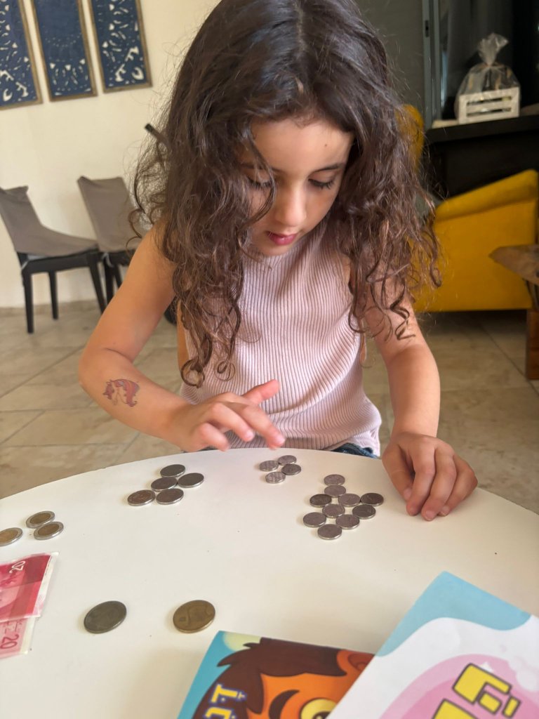 ילדה ממיינת מטבעות עם הערכה