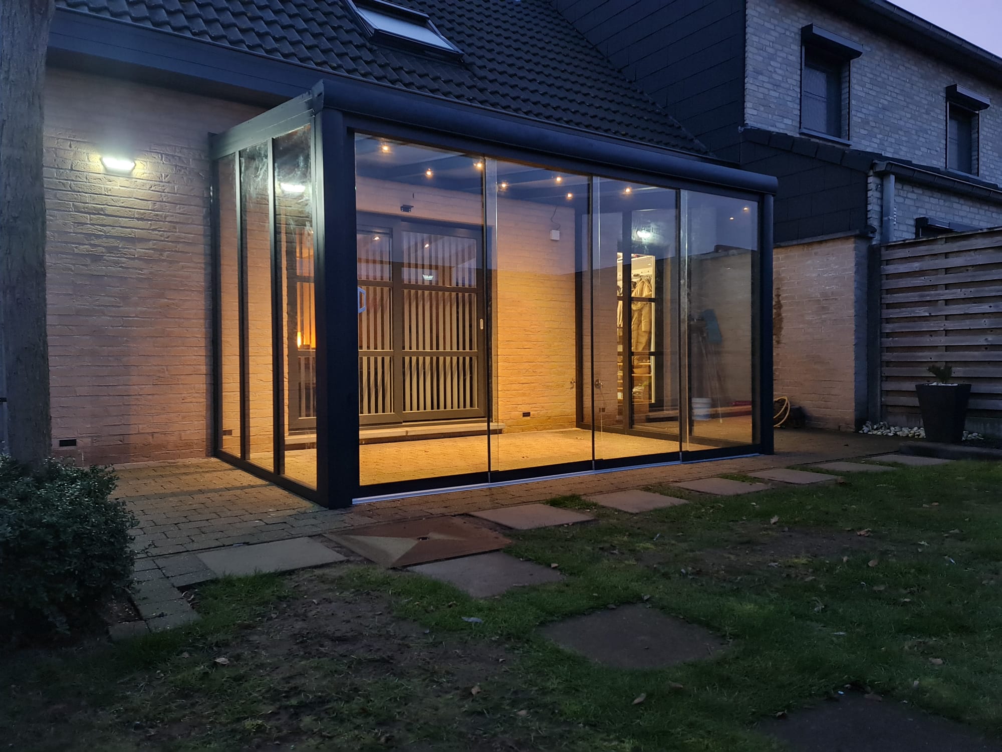 Veranda met glazen schuifwanden en geïntegreerde LED-verlichting door I.D. Construct