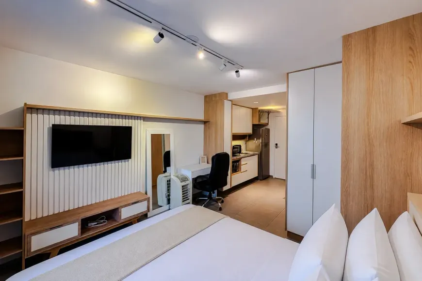 Interior de studio decorado do Infini Vila Mariana - cama, cozinha e área de trabalho