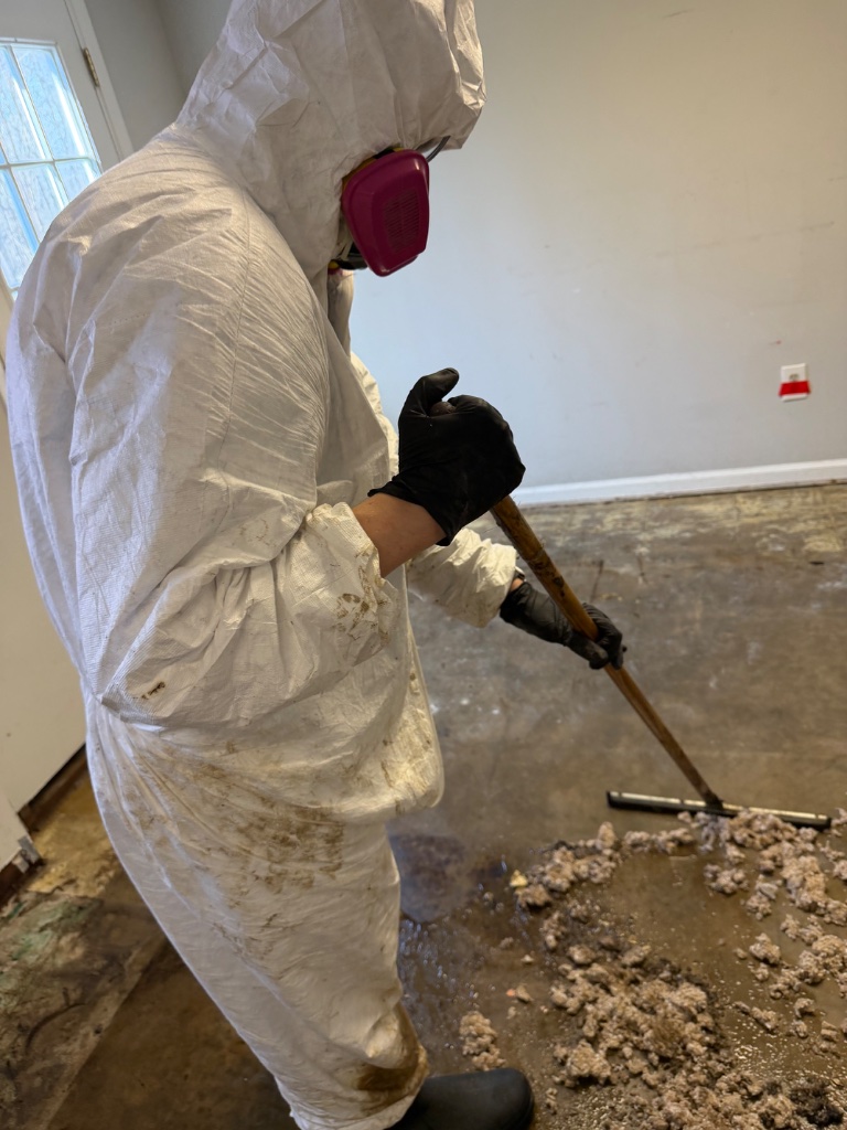 Asbestos mastic scraping — certified technician in hazmat suit