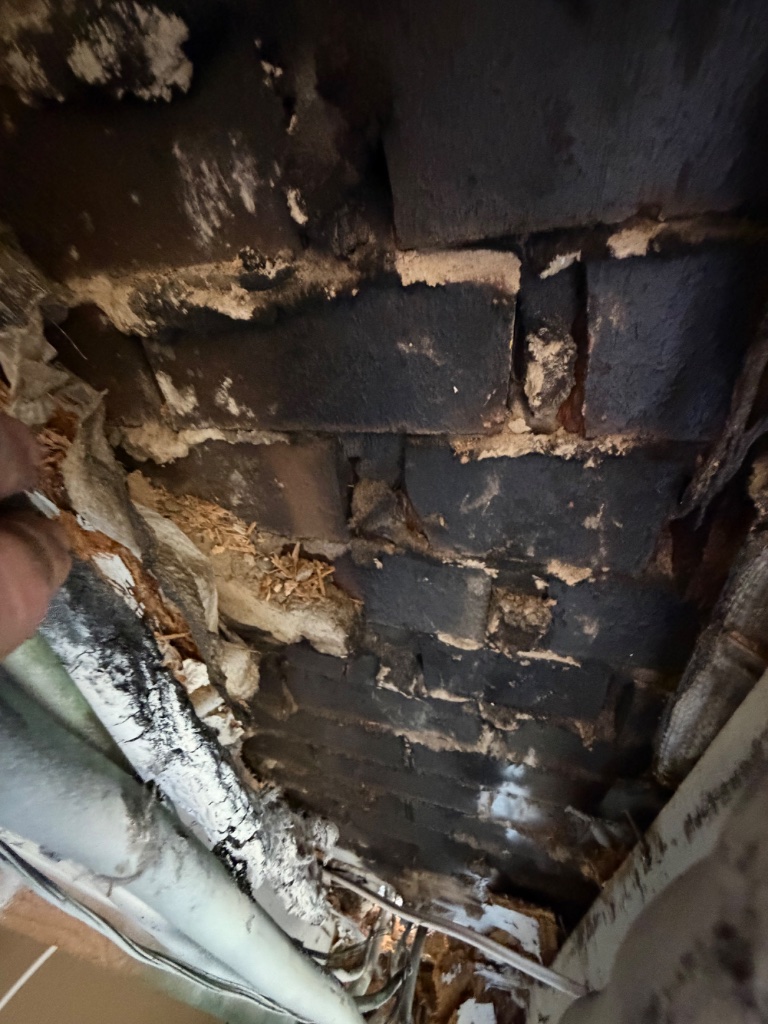 Fire-damaged ceiling — charred framing and insulation exposed