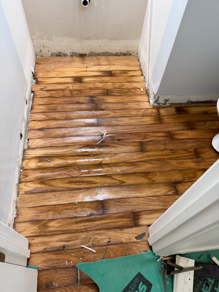 Buckled and warped hardwood floor — bathroom water damage