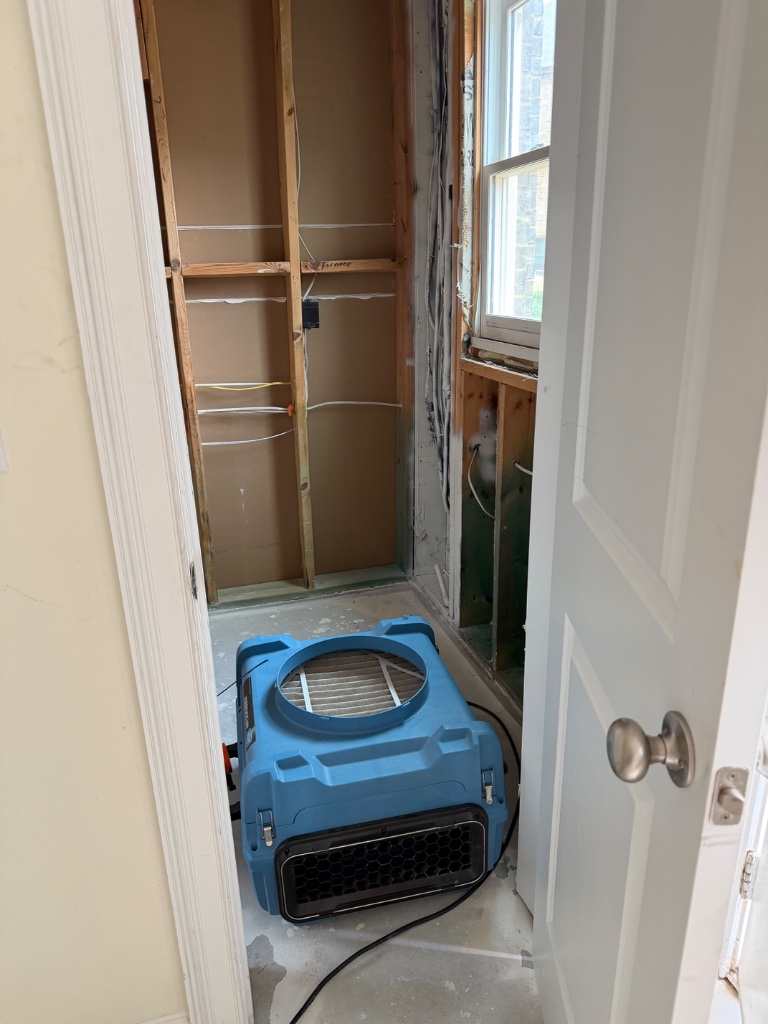 Post-fire cleanup — air mover deployed after structural demo