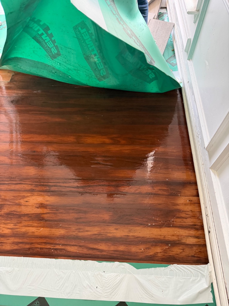 Flooded hardwood floor with protective barrier — water damage mitigation