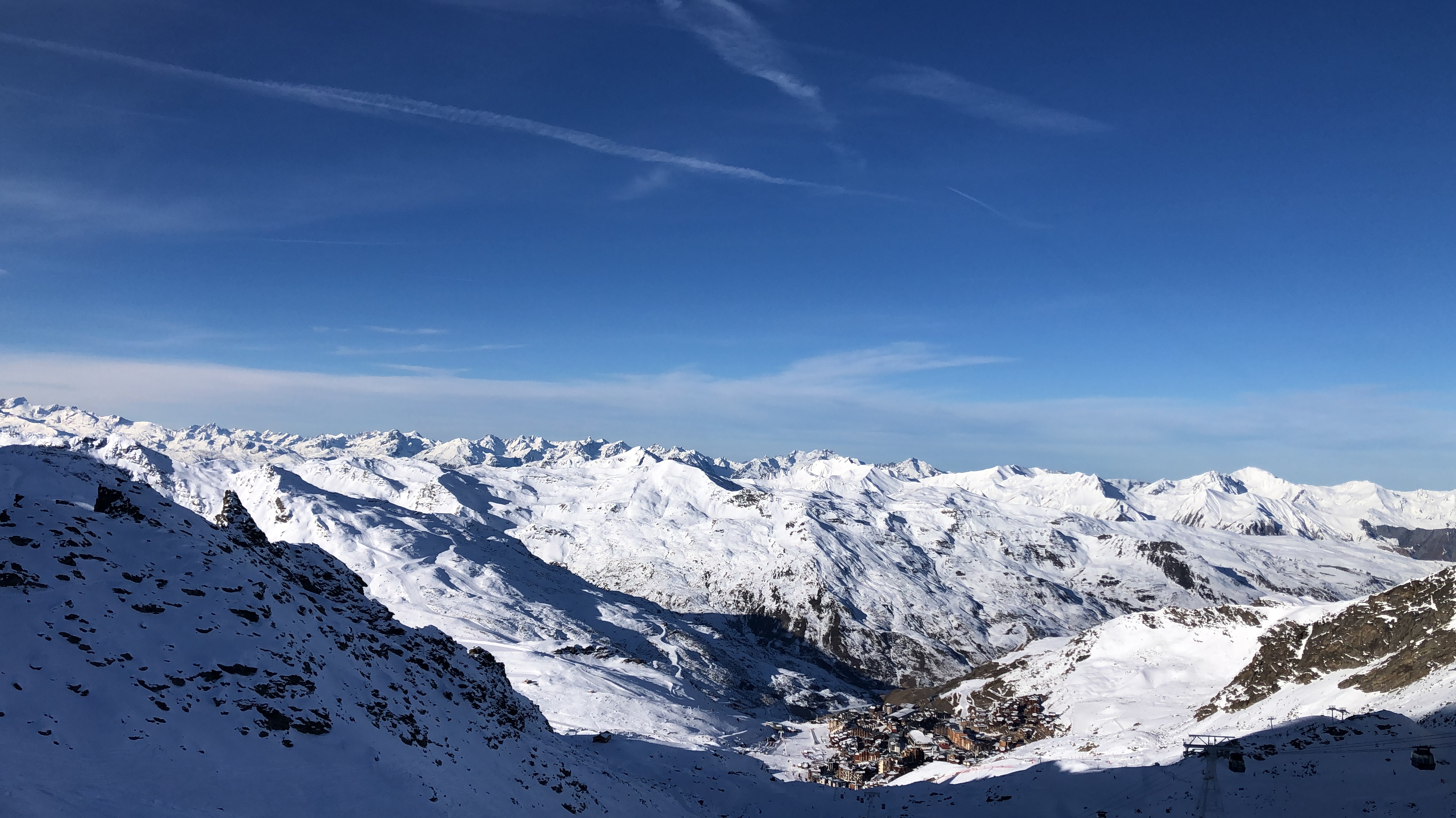 Snow-covered alpine valley with a mountain village below
