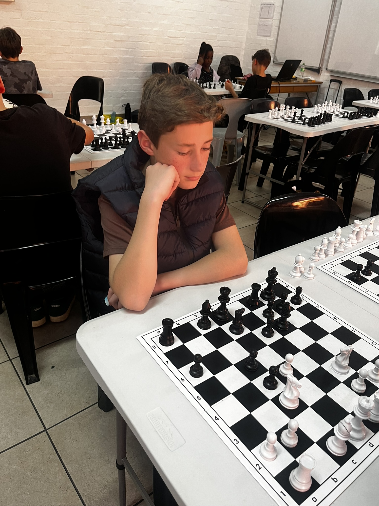A young player deep in concentration at the chess board during the club session