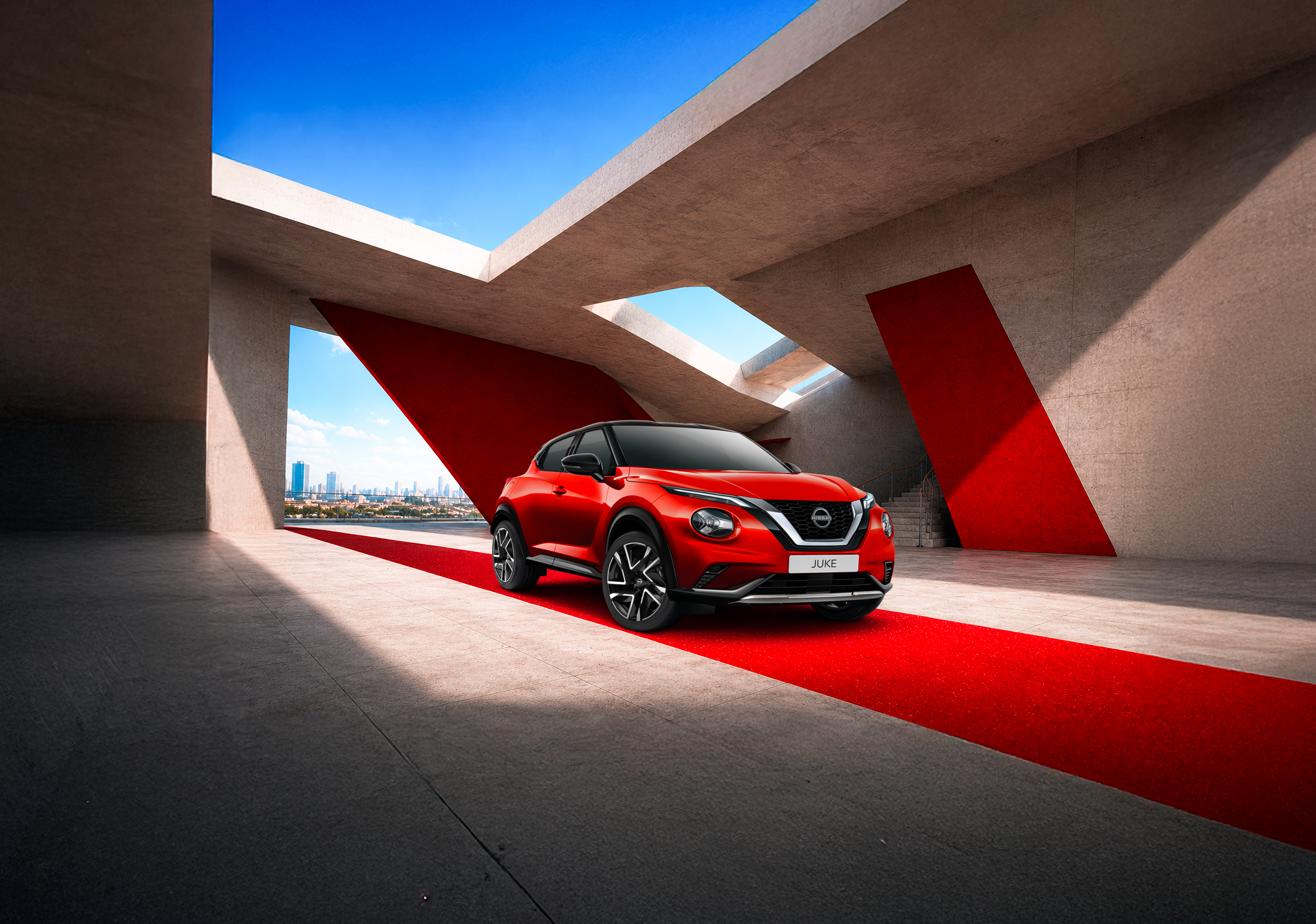 Nissan Juke Hybrid rouge dans une architecture béton