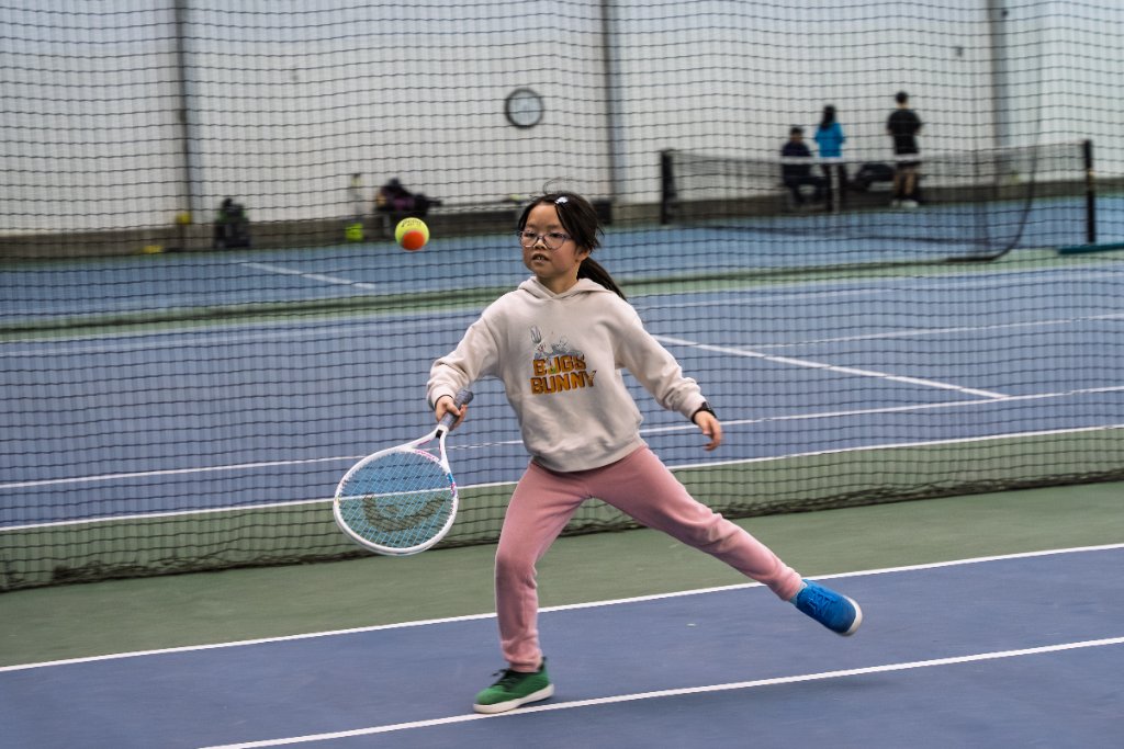 Girl hitting forehand in pink pants