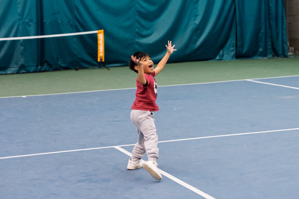 Young boy celebrating on tennis court