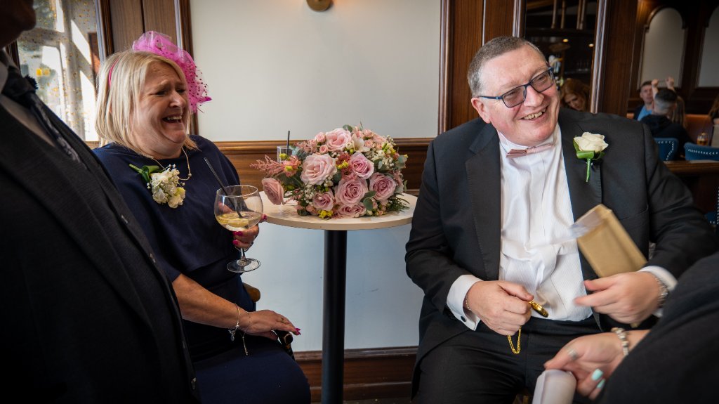 Woman in navy dress and man in tuxedo at a wedding table