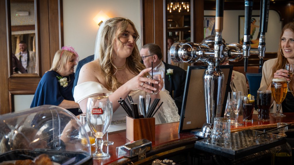 Bride holding a glass at a pub bar