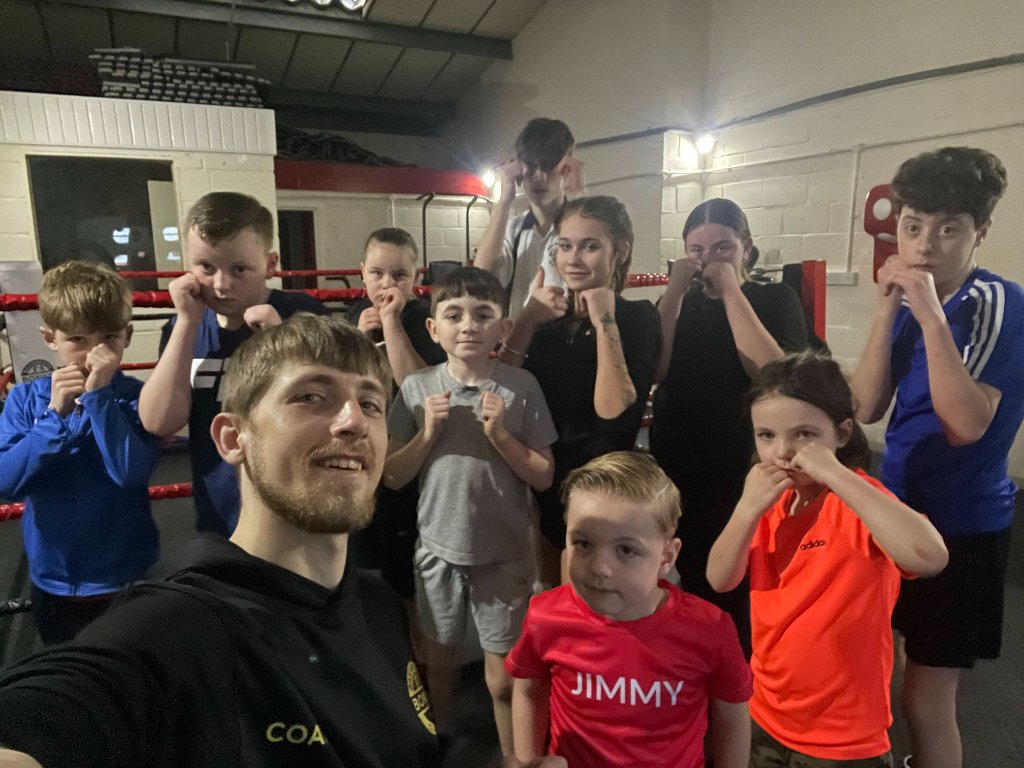 Kids aged 5-10 practising boxing technique with a coach at Basingstoke Boxing Classes