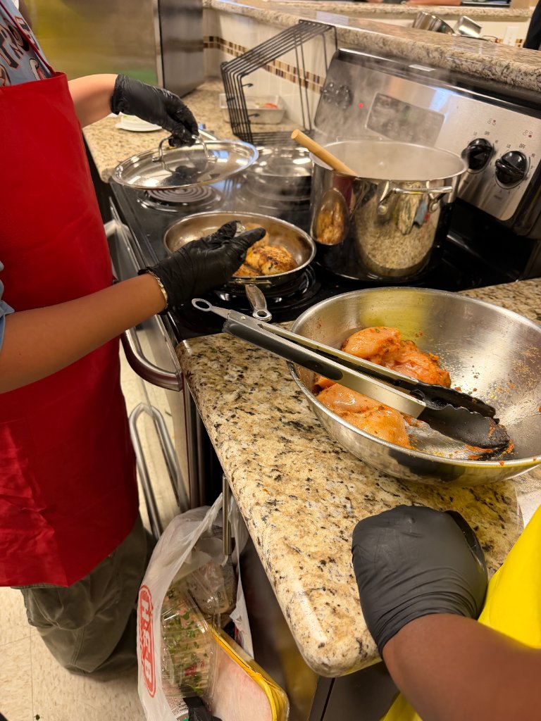 Participants cooking chicken on the stovetop