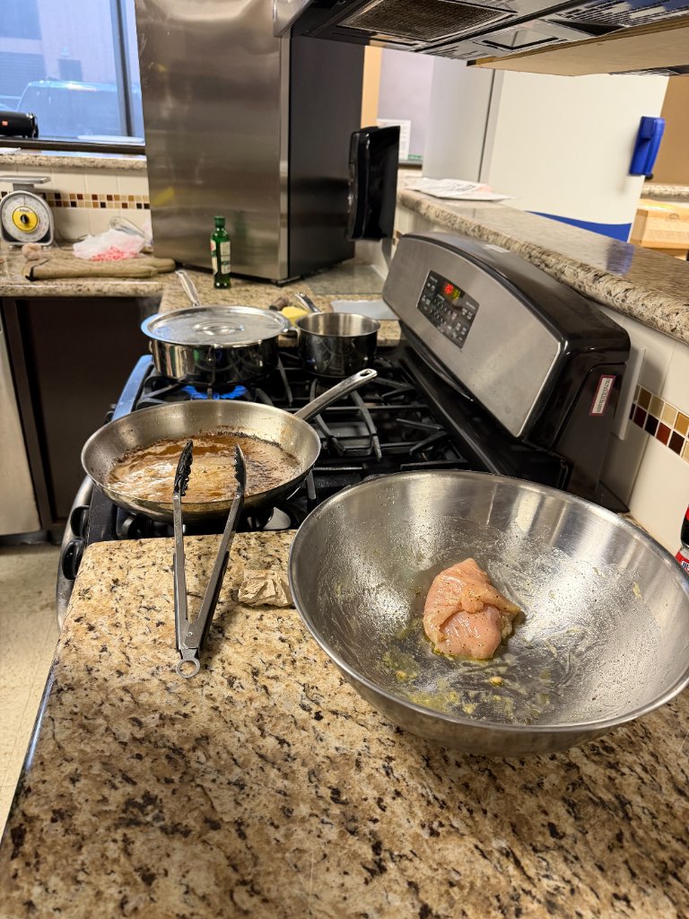 Raw chicken prepped in a mixing bowl on the stove