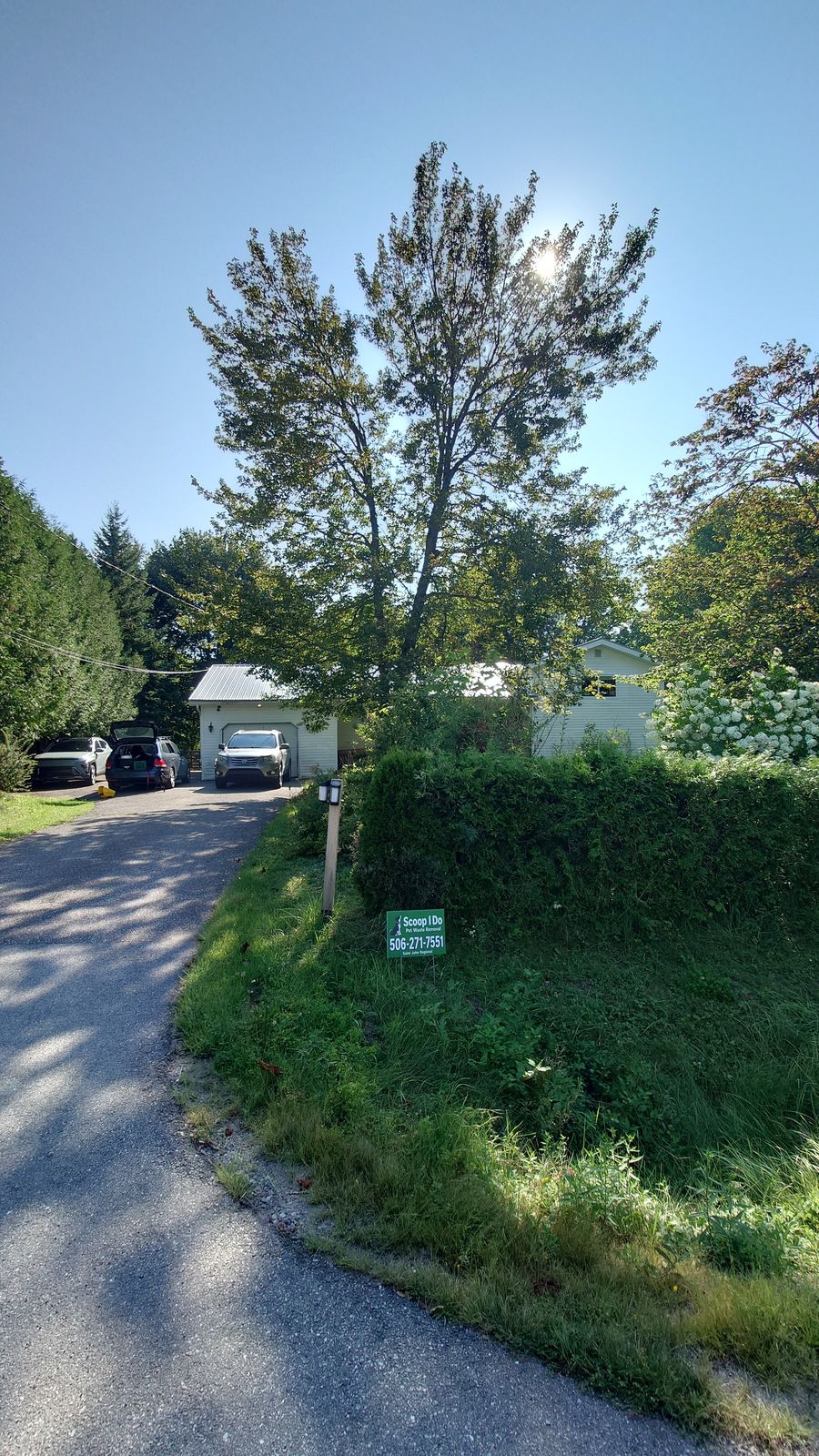 A Scoop I Do yard sign at the entrance to a client's driveway