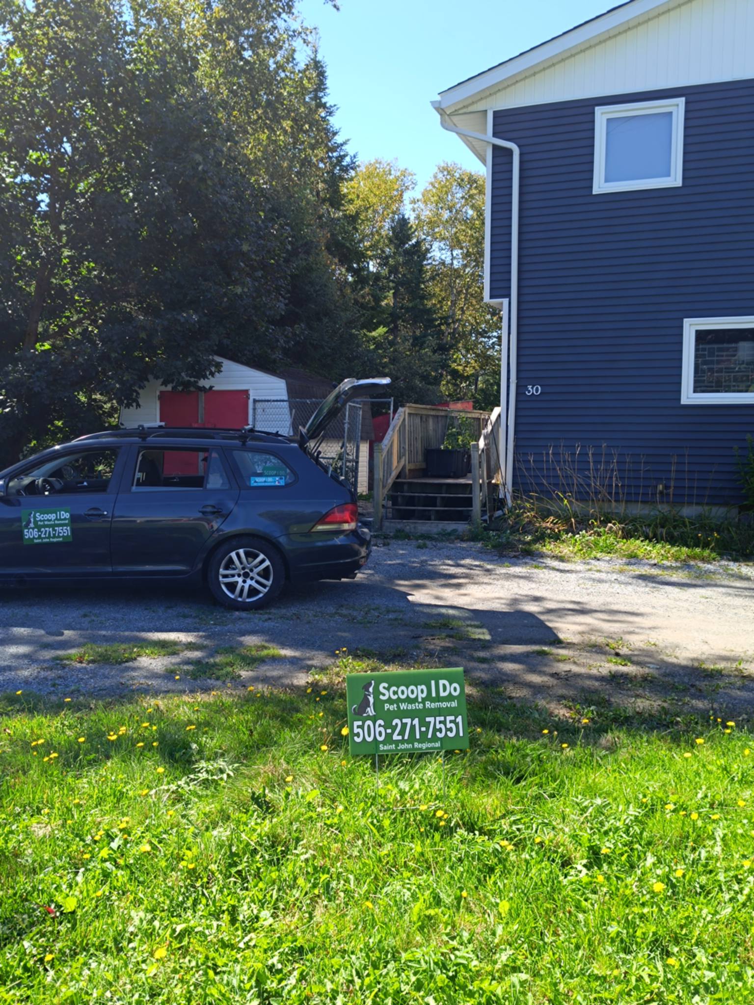 The Scoop I Do service vehicle and yard sign at a client's home